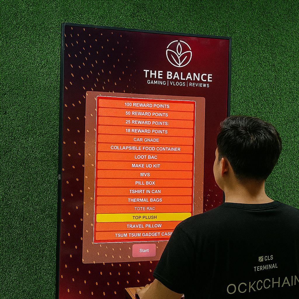 Guest playing interactive event game at exhibition booth in Dubai, pressing button to win prize, with branded screen display and selfie sharing feature for engagement.